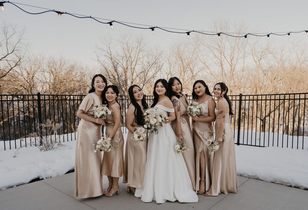 bride and bridesmaids posed on The Eloise patio surrounded by white snow